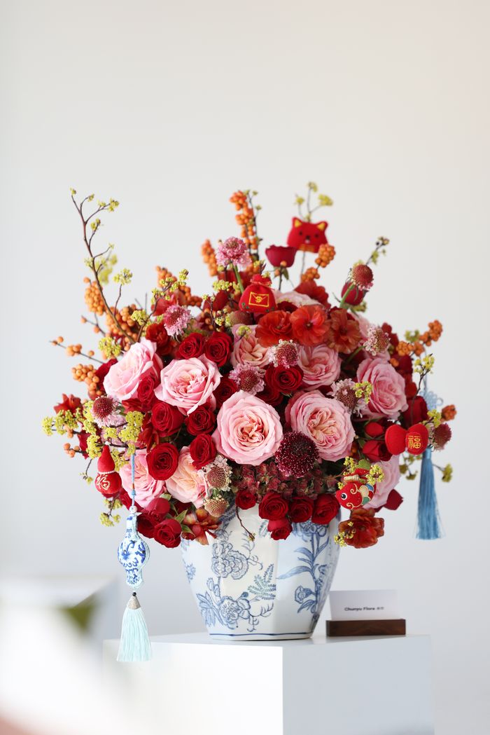 Stunning floral arrangement with red and pink roses in a decorative vase, perfect for elegant interior decor.